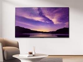 책이 놓여진 원형 테이블이 있는 거실에 배치된 LG 벽걸이 TV